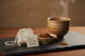 Quiet Evenings Hojicha tea bag with roasted powder bowl and steaming Japanese teacup in soft evening light